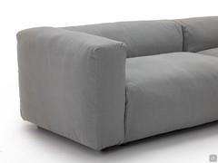 Détail de l'accoudoir large et des sièges rembourrés qui mettent en valeur le style moderne et informel.
