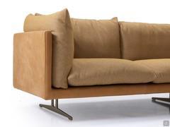 Détail de l'élégante combinaison ton sur ton du cadre en cuir entourant les coussins recouverts de tissu