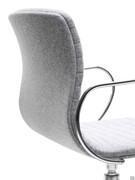 Détail de la courbure ergonomique du dossier relié à l'assise monocoque et de l'accoudoir métallique qui suit son profil.