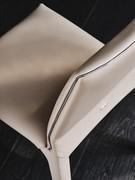 Détail du profilé de couleur bronze, commun à toutes les chaises Penelope, quel que soit le revêtement choisi.
