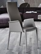 Chaise Norma de Cattelan avec dossier haut, accoudoirs et pieds revêtus d'un tissu assorti à l'assise.