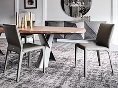 Salle à manger élégante avec une table Mad Max et des chaises Penelope recouvertes de cuir assorti au piètement de la table.