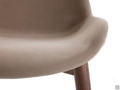Détail de l'assise incurvée de la chaise Clara, légèrement rembourrée et entièrement capitonnée pour un confort maximal.