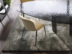 Exemple de chaise d'appoint avec différentes configurations de revêtement en cuir, présentée ici en combinaison avec la table Source de la même collection.