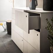 Détail du tiroir de la commode Jess, avec poignée Foro et bords revêtus de série en mélaminé tramé Lino grey