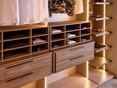 Des porte-chemises reposent sur les tiroirs. Les compartiments ouverts peuvent être équipés de boîtes de rangement en tissu gris. Pour optimiser l'espace intérieur, les tiroirs peuvent être enrichis d'organiseurs, de séparateurs et de porte-horloges en si