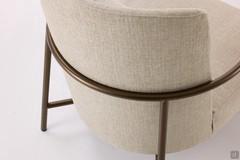 Vue arrière du fauteuil Maggie, avec sa fascinante combinaison de parties rembourrées et d'éléments structurels métalliques fins.