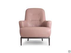 Détail du fauteuil rembourré René, aux volumes généreux surélevés par rapport au sol grâce à la base métallique aux pieds hauts