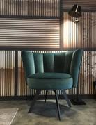 Fauteuil Petra en forme de coquille avec dossier matelassé typique à bandes verticales et pieds métalliques hauts et élancés