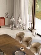Lampe suspendue Guadalupe à 8 abat-jour, associée à une importante table en bois de plus de 3 mètres.