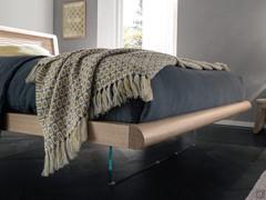 Détail du cadre de lit en chêne massif du lit Sebastian, avec pieds en verre plat