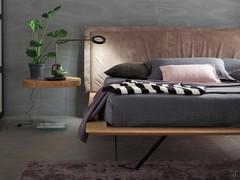 Lit Miguel avec de hauts pieds métalliques et une tête de lit rembourrée, recouverte de tissu ou de similicuir