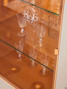 Vitrine avec étagères en verre et porte avec cadre en métal laqué. Le cadre et l'intérieur suivent la finition laquée mate des autres éléments.