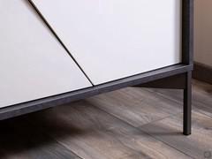 Détail du piétement métallique à pieds hauts : notez les portes en retrait de quelques centimètres par rapport à la structure affleurante. Un choix délibéré, pour alléger le volume du buffet.