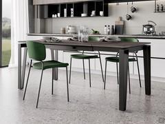Table à rallonge Logan dans la version avec un plateau en stratifié effet pierre brun foncé combiné à une structure métallique peinte en noir. Le mécanisme d'extension sous le plateau est peint de la même manière que la base.