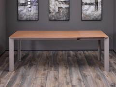 Table profilée entièrement déployée, avec la rallonge de 60 cm sous le plateau tirée. Les rallonges sont toujours assorties au plateau