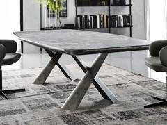 Table Mad Max dans la version avec plateau en céramique Keramik (finition non disponible) soutenue par un important sous plateau aux angles biseautés en laqué gris brossé mat assorti à la base en acier.