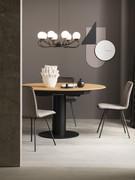 Table Bolivar à rallonge avec piètement en métal laqué noir ; grâce à la géométrie du plateau et du piètement, l'ergonomie est excellente ; fermée, elle accueille confortablement 4 convives, la capacité étant presque doublée lorsqu'elle est rallongée.