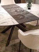 Table Juno en version ronde à rallonge. Plateau en grès Ø 140 cm avec rallonges centrales en bois de noyer Canaletto.