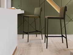 Tabouret fixe revêtu de similicuir ou de tissu écossais, avec cadre revêtu d'un tissu assorti à l'assise.
