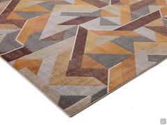 Détail de la moquette à poils courts à motifs dans les tons orange et marron avec des pointes de couleur beige et grise en contraste.