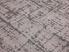 Détail du tapis Cortina avec un motif abstrait bicolore donnant un effet tacheté