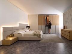 Camera da letto realizzata con l'armadio Ocean (laccato opaco e fashion wood) unito al comò e ai comodini Mason, oltre che al letto Freeport e alla sua boiserie