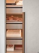 Maniglia integrata a contrasto con l'anta. Gli interni possono essere attrezzati con cassettiere ed accessori estraibili