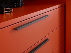 Maniglie integrate in metallo, montate di serie su tutti i cassetti interni Wide in finitura umber shine