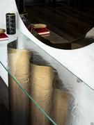 Le increspature del vetro cotto sulla consolle Nettuno richiamano la forma curva e dinamica del basamento in metallo verniciato