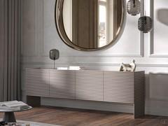 Credenza moderna ad ante dogate Harmony mostrata all'interno di un contesto giorno in abbinamento con specchiera e lampada della stessa collezione