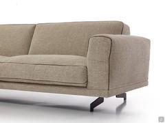 Particolare del divano Raymond qui proposto con base rivestita in tessuto, disponibile anche in noce Canaletto