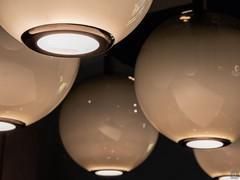 Dettaglio del cerchio inferiore in metallo cromato nero, dal quale la luce led passa e si diffonde alle superfici sottostanti
