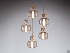 Lampada a sospensione in vetro Pyrex© Tetide nella versione a 5 diffusori, col modello da 15 cm in vetro ambrato