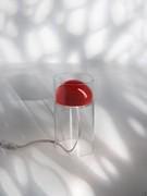 Particolare del diffusore esterno cilindrico in vetro che contiene un riflettore interno in metallo, da cui scende il cavo in tessuto grigio