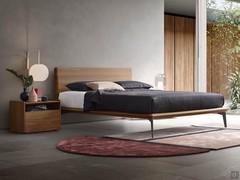 Letto in legno con piedini alti Lacrosse, qui con giroletto e testiera in noce