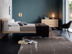 Zona letto completata dal letto Vicente con cuscini testiera. Le forme "irregolari" della testiera vengono mitigate dai morbidi cuscini alti cm 55