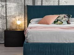 Particolare del letto matrimoniale Milleletti nella versione con giroletto contenitore e testiera Soft con cuciture