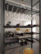 Vano della libreria Milton attrezzato con ripiani portabottiglie e ripiano completo di portabicchieri, con parte superiore in vetro trasparente fumé e tutte le parti metalliche in metallo verniciato antracite