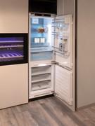 Dettaglio del frigorifero combinato ad incasso e della cantina vini con cassetti estraibili in legno