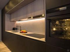 Zona operativa con pensili in legno e piano in Laminam Piasentina grigio fiammato