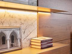 Una delle peculiarità che rende unica la parete Replay 08 è l'incontro tra diversi materiali. In questo caso la ceramica lucida, il noce canaletto e il metallo verniciato delle mensole (ribadito nella colonna vetrina sul lato opposto)