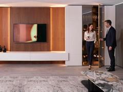 Parete attrezzata Lounge realizzata combinando la boiserie in legno essenza, le colonne armadio e le basi sospese della collezione Royal