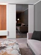 Colonne armadio Lounge in affiancamento: la centrale con ante in vetro Stop Sol colore bronzo e telaio in metallo ottone, le laterali in laccato opaco lino con lavorazione ad inserto metallico 2:2 in tinta (quest'ultima disponibile solo su progetto)