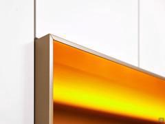 Dettaglio della cornice del vano a giorno che mostra la lavorazione a 45° degli spigoli e la finitura effetto metallizzato color ottone