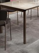 Particolare del taglio geometrico della gamba, in questo caso in metallo verniciato bronzo, con piano in pietra ceramica lucida onice ambra