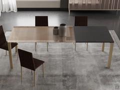 Tavolo moderno David utilizzato per arredare una sala da pranzo moderna: si notano la particolare finitura del piano in vetro bronzo con serigrafia effetto "spinato", le due allunghe in laminato antracite e la struttura in metallo verniciato champagne