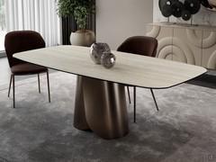 Tavolo con base centrale arrotolata in metallo Miles, nella versione sagomata a botte in ceramica opaca travertino