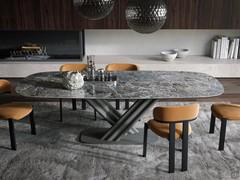 La finitura pregiata del piano in ceramica conferisce una importante presenza scenica al tavolo, a sua volta alleggerito dalle forme dinamiche del basamento