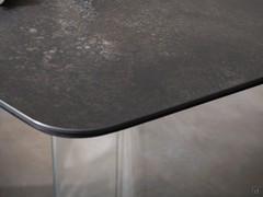 Dettaglio del piano in ceramica opaca Ossido Nero, con sottopiano in mdf tinto nero e basamento in vetro trasparente